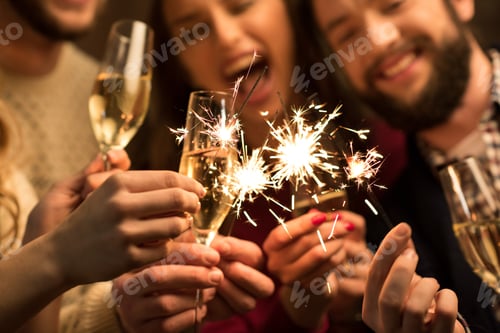 Preview: Close-up view of happy people with glasses of champagne and sparklers