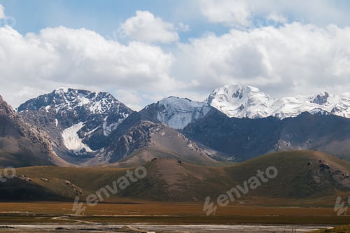 Preview: Majestic snowcapped mountain peaks under a cloudy sky