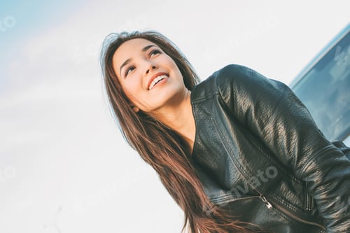 Preview: Smiling Young Woman Looking Up in Bright Daylight