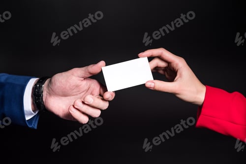Preview: Close-up partial view of male and female hands holding blank card isolated on black