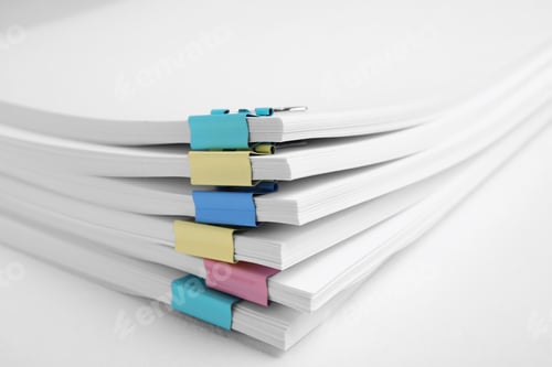 Preview: Many sheets of paper with colorful clips on white background, closeup