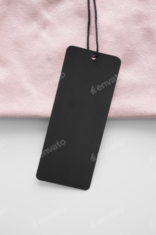 Preview: Black clothing tag mockup on a soft pink t-shirt.