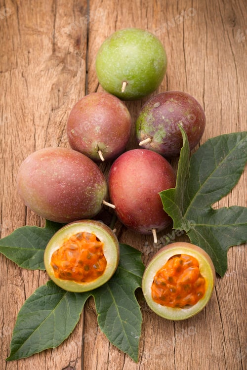 Preview: fruits of gulupa on vine wood table, Passiflora pinnatistipula