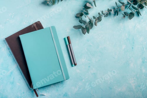Preview: Blue and brown notebooks, fineliner markers with green eucalyptus plants