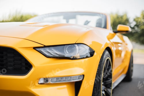 Preview: Particle view of yellow brand new modern luxury sport car parked outdoors.