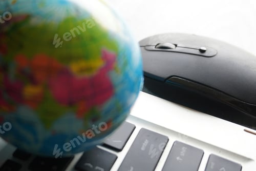 Preview: Close up image of globe, laptop keyboard and computer mouse.
