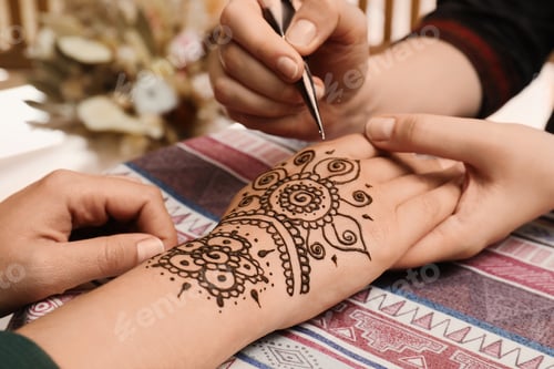 Preview: Master making henna tattoo on hand, closeup. Traditional mehndi