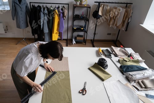 Preview: Design clothes, prepare fabric for sewing and cutting. Top view of girl sewer draw pattern on fabric