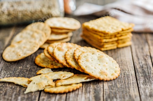 Preview: A stack of crackers neatly arranged on wooden tabletop.