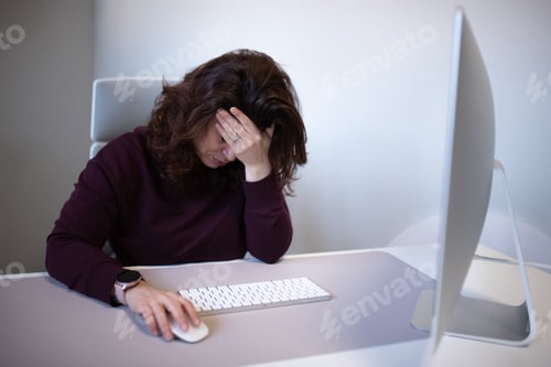 Preview: Disappointed frustrated woman sitting at the table in the office.