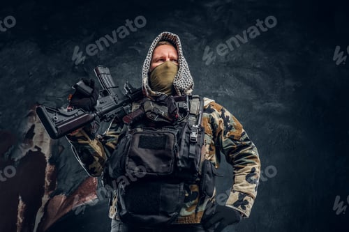 Preview: Special forces soldier wearing body armor holding an assault rifle. Studio photo