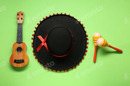 Preview: Mexican sombrero hat, maracas and guitar on green background, flat lay