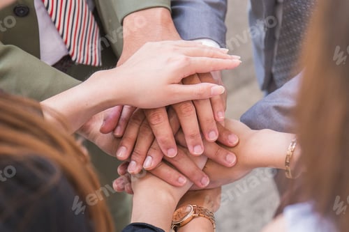Preview: Close up creative team putting their hands together in circle