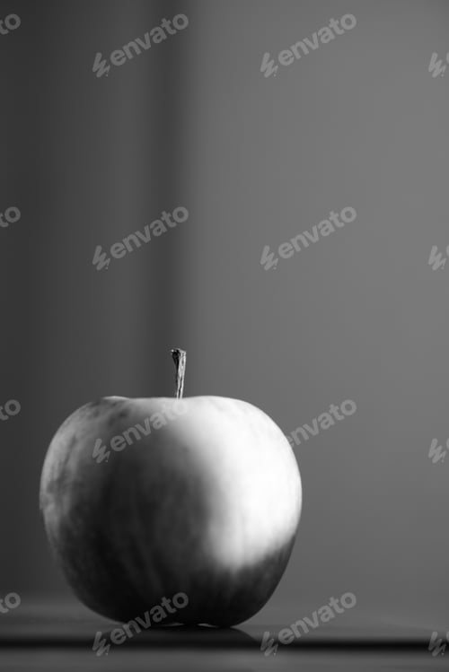 Preview: Greyscale of an apple reflecting on the table with a blurry background