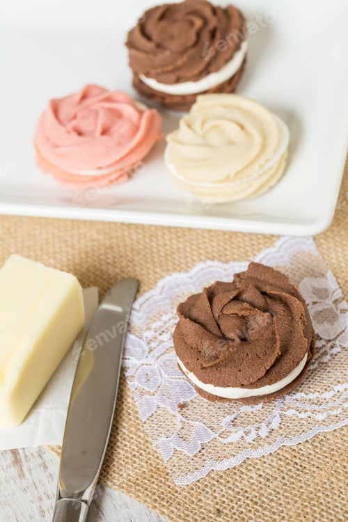 Preview: Chocolate And Vanilla And Strawberry Sandwich Cookies With Butter And Knife