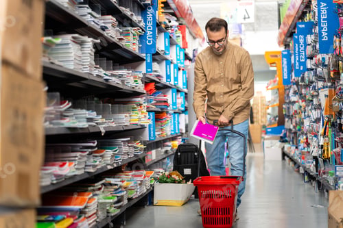Preview: Adult man choosing notebooks in stationery store