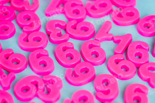 Preview: High angle view of pink plastic numbers on blue surface
