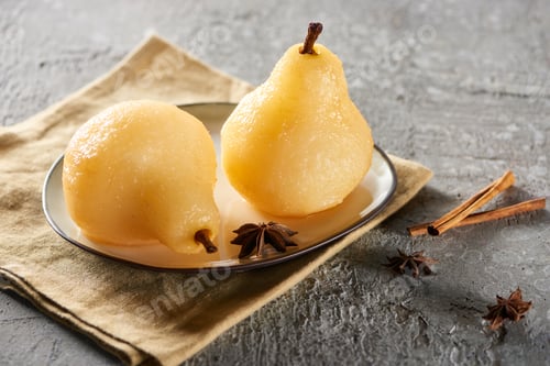 Preview: delicious pear in wine with anise and cinnamon served on plate on napkin on grey concrete surface
