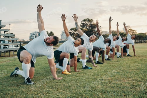 Preview: Full length shot of a group of young rugby players training on the field during the day