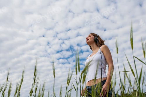 Preview: Woman in field under fluffy cloud looking away, Palma de Mallorca, Islas Baleares, Spain, Europe