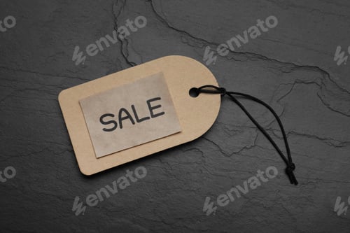 Preview: Tag with word Sale on dark stone table, top view. Black Friday