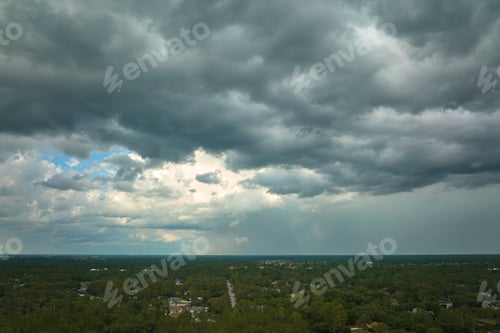 Preview: Dark stormy clouds forming on gloomy sky before heavy rainfall over suburban town area