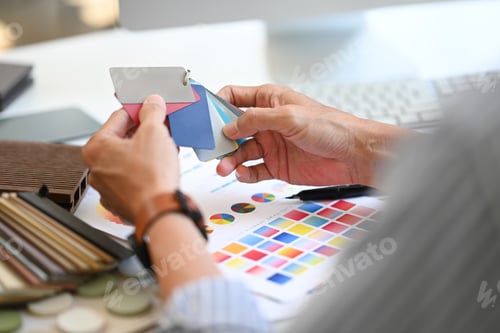 Preview: Close up Interior designer holding color samples working on new design project at office