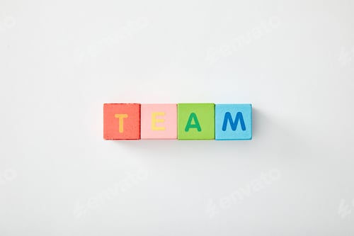Preview: top view of team lettering made of multicolored cubes on grey background
