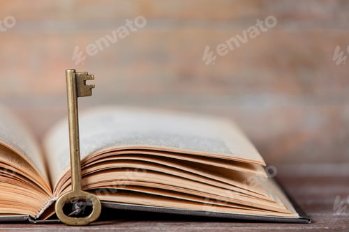 Preview: Retro key and opened book on wooden table.