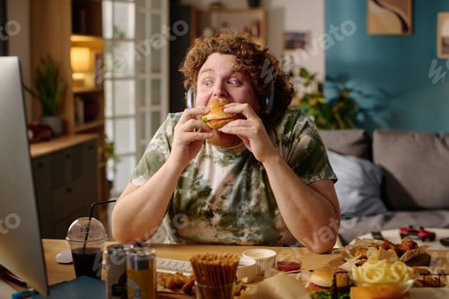 Preview: Person Sitting in Cozy Room Eating Large Sandwich