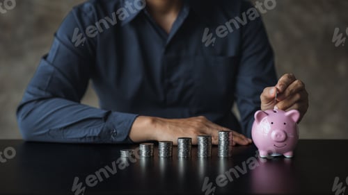 Preview: A businessman holding a coin in a piggy bank.