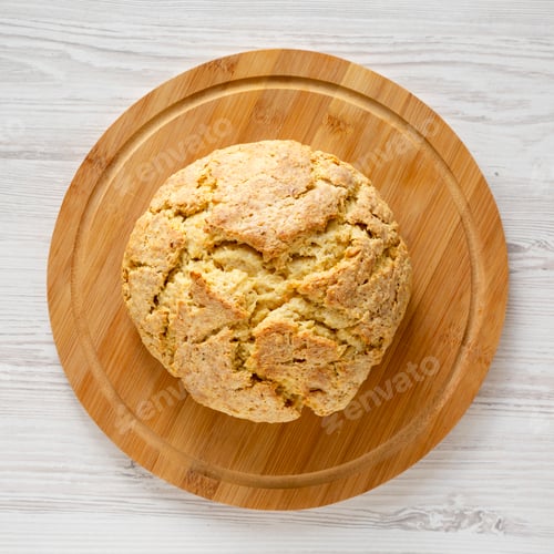 Preview: Homemade Irish Soda Bread on a bamboo board on a white wooden surface, top view. Flat lay, overhead