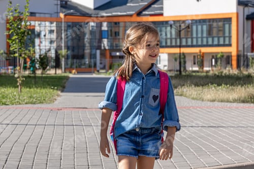 Preview: A cute little girl with a backpack goes home from school.