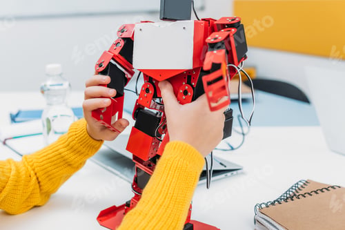 Preview: cropped view of schoolkid playing with robot model at STEM educational class