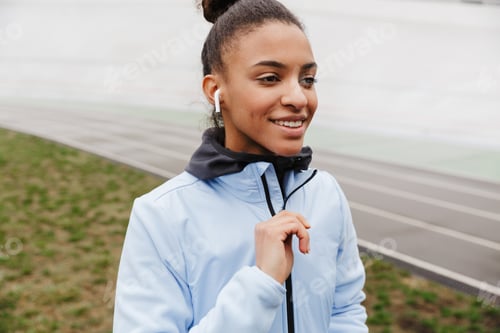 Preview: Attractive young healthy african sportswoman listening to music