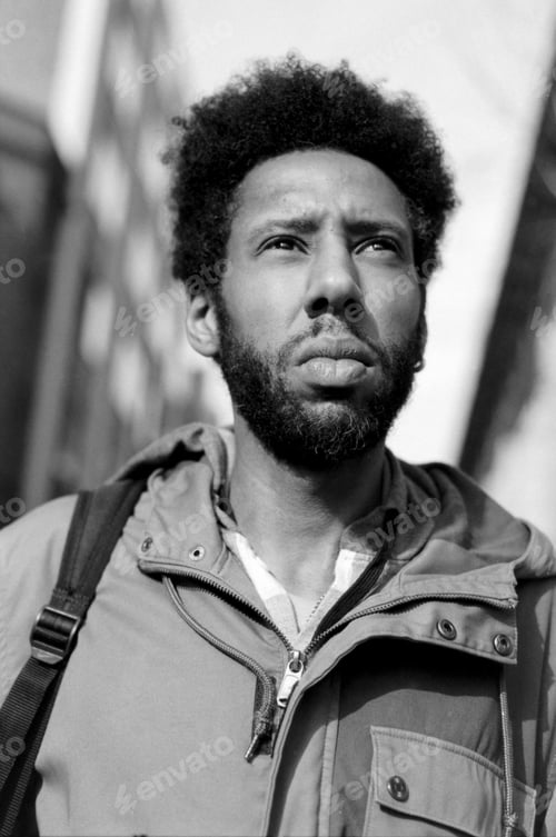Preview: Young man with afro hair looking up in black and white analog photo