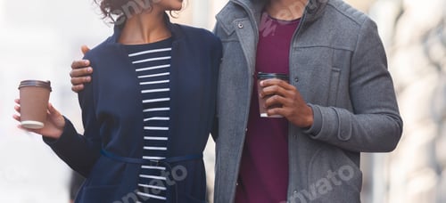 Preview: Black couple holding paper cups with coffee while walking