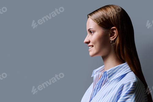 Preview: Profile portrait of young teenage girl, gray studio copy space background