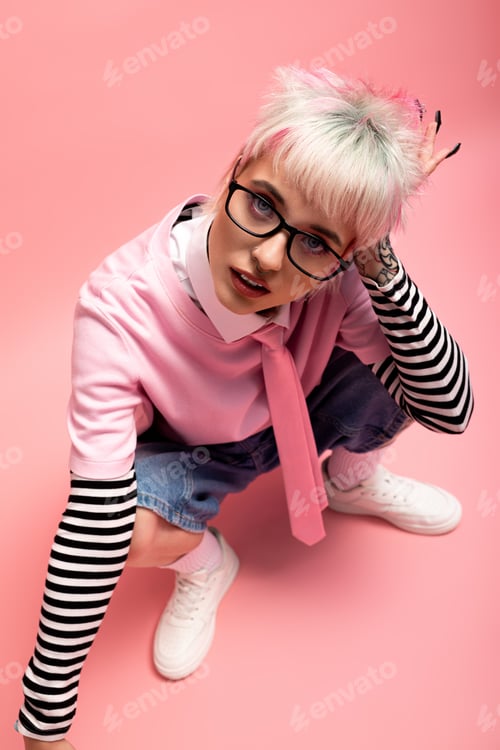 Preview: Portrait of a youthful woman in a playful pink outfit with a vibrant pink backdrop