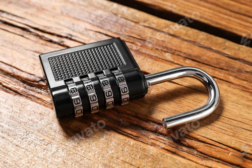 Preview: One steel combination padlock on wooden table, closeup