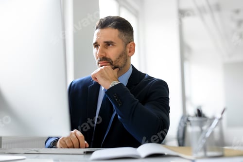 Preview: Busy middle aged entrepreneur man working on computer in office, looking at monitor, reading news or