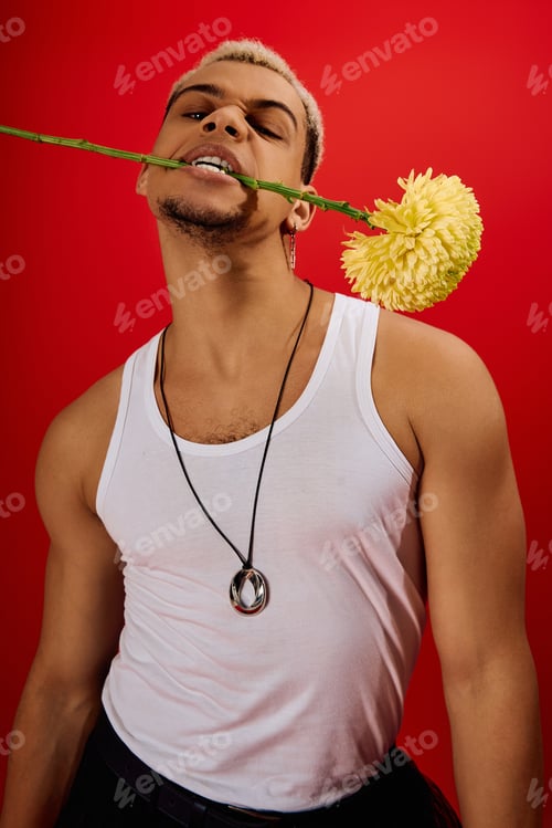 Preview: Daring style of a young man expressing confidence in a vibrant red studio setting