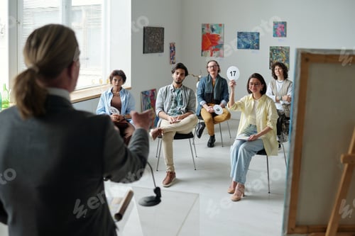 Preview: Group of people sitting at auction in art gallery
