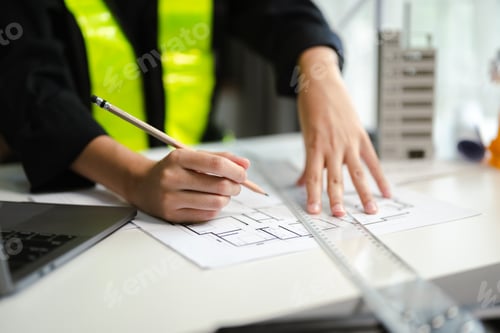Preview: business man hand working and laptop with on on architectural project at construction site