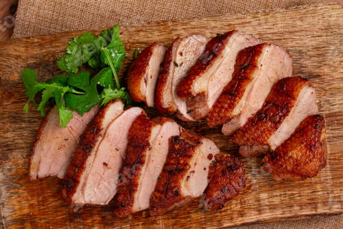 Preview: Roast duck breast, sliced, on a wooden chopping board,close-up, no people,