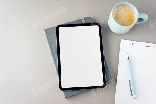 Preview: Top view of a digital tablet with a white screen, a pen, a notepad and a cup of fresh coffee. Do it.
