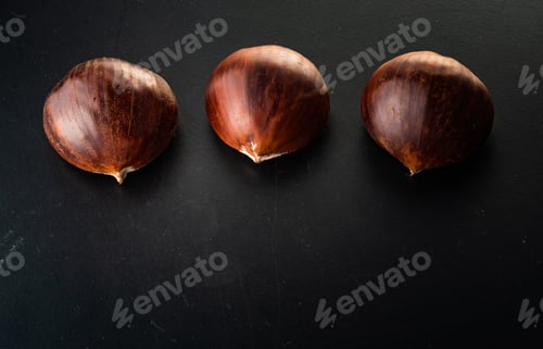 Preview: Three chestnuts isolated on black background