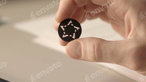 Preview: Close up view of a button from a shirt with pattern in the shape of a star