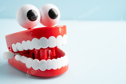 Preview: Tooth funny toy denture red color jaw and eye on white background with copy space.