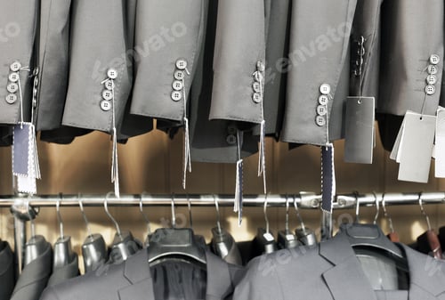 Preview: Row of elegant suits jacket on hangers, apparel store